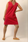 Person wearing a red dress on a plain background
